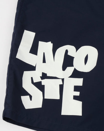 Lacoste – Badeshorts mit Logo-Schriftzug in Marineblau