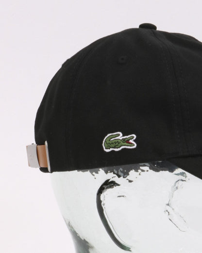 Lacoste – Baumwollkappe mit Kontrastriemen in Schwarz