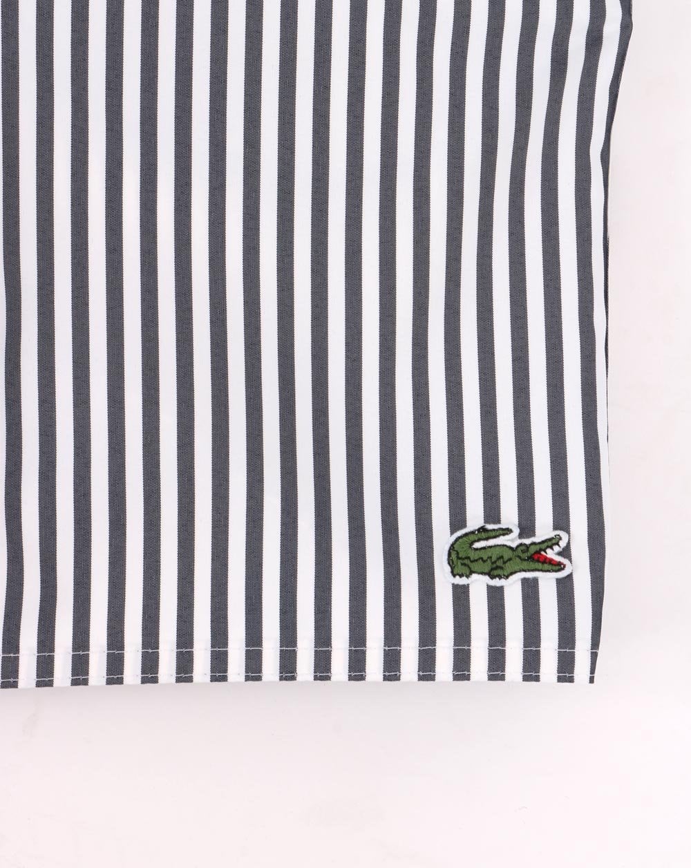 Lacoste – Gestreifte Badeshorts in Marineblau/Weiß