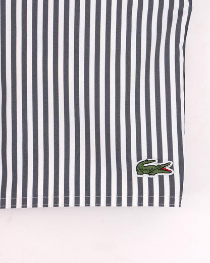 Lacoste – Gestreifte Badeshorts in Marineblau/Weiß