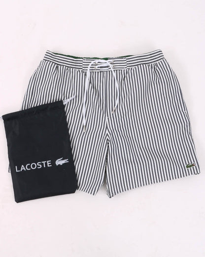 Lacoste – Gestreifte Badeshorts in Marineblau/Weiß